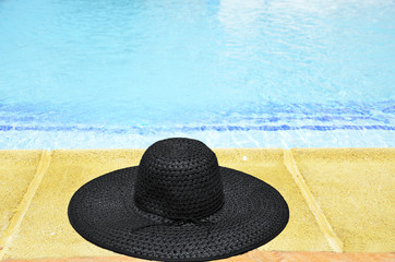 Fototapeta na wymiar woman's hat at the feet of the pool
