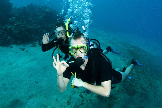 scuba divers make OK sign