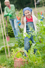 Gardening -  girl helping mother in the vegetable garden