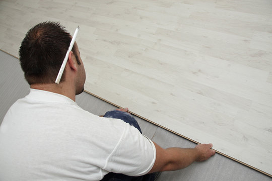 homme posant parquet flottant stratifi&eacute;