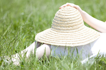 麦藁帽子をもつ女性の手元