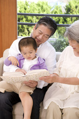 孫に本を読む老夫婦