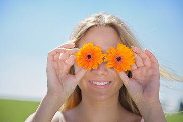 Young Woman holding flowers before her eyes