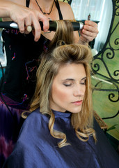 woman in hair salon having hair curled