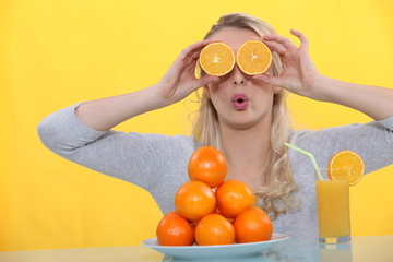 A woman playing with oranges