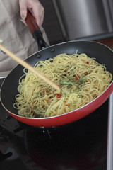 パスタを炒める女性の手元