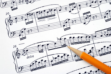 Fototapeta premium Compose the song on a music sheet with a pencil