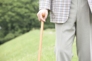 公園を杖をつきながら散歩する老人