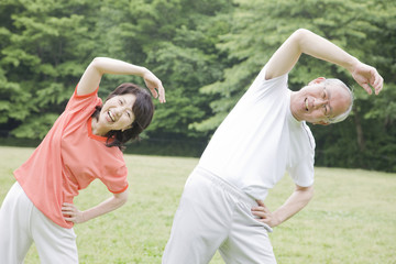公園でラジオ体操をする老夫婦