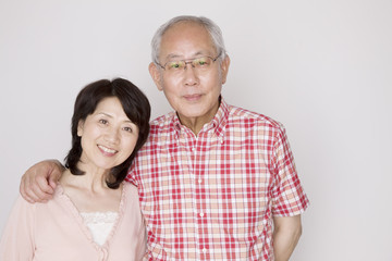 妻の肩に手をのせて寄り添っている夫