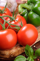 Fresh tomatoes and paprika on the wooden cutting board