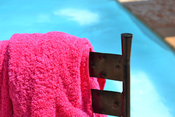 Serviette éponge rose au bord de la piscine
