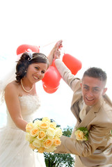 Bride and groom with red balloons