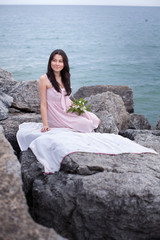 Nice young woman with flowers near waterfront