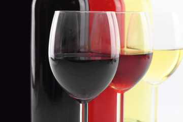 Three colors of wine in bottles and glasses