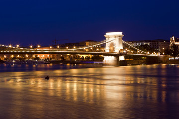 Budapest skyline, reflected on the river bridge at night.