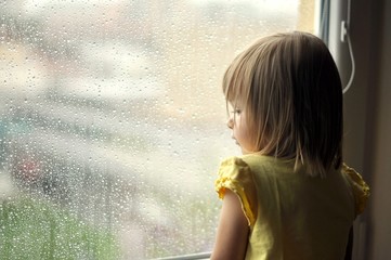 la jeune fille regarde par la fenêtre