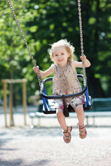 Swinging preschooler girl having fun