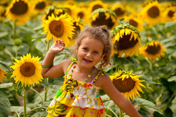 fillette de 4 ans souriante dans un champs de tournesols