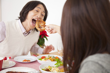 女性にチキンを食べさせてもらう男性