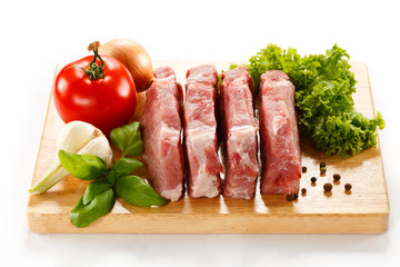 Raw pork on cutting board and vegetables