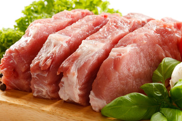Raw pork on cutting board and vegetables