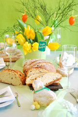 Gedeckter Ostertisch mit Blumen und Osterlamm