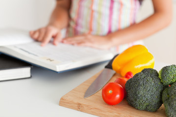 Young woman consulting a notebook while standing