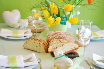 Gedeckter Ostertisch mit Blumen und Dekoherzen