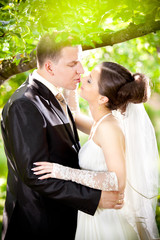 Young  just married couple kissing and hugging in park
