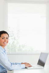 Beautiful woman working with her laptop and posing while sitting