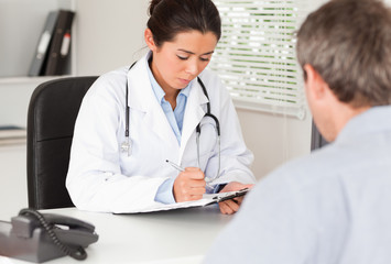 Pretty female doctor consulting the patient's medical analysis