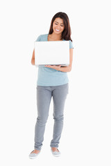 Beautiful woman holding a laptop while posing