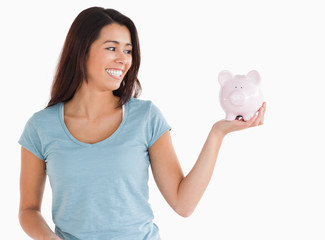 Good looking female holding a piggy bank