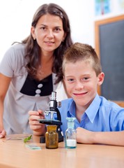 Wise boy with microscope and teacher