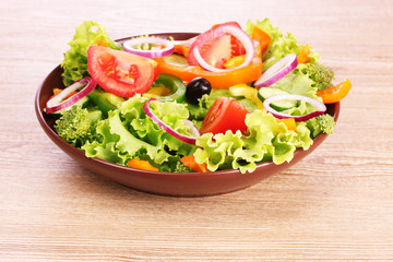 many vegetables on the plate on a wooden background