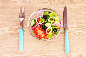 salad of fresh vegetables in a plate and cutlery