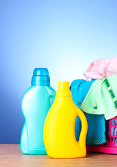 Colorful towels and liquid laundry detergent   over blue