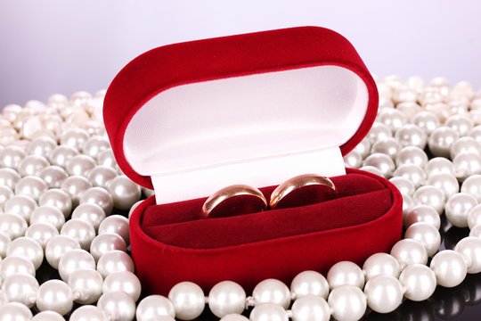 wedding rings in a box and pearls