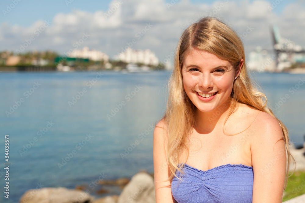 Wall mural pretty young blond woman by the bay