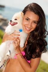 Pretty young brunette woman with her Pomeranian puppy