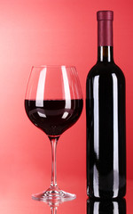 Wine bottle and glass on red background