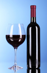 Wine bottle and glass on blue background