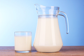 Pitcher and Glass with milk on blue background