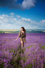Young beautiful girl in the brown dress in lavender field