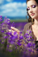Young beautiful girl in the brown dress in lavender field