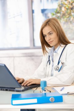 Young doctor browsing internet in office