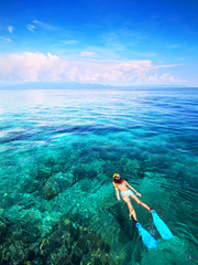 Young woman snorkeling in the coral reef in the tropical sea. Bunaken island. Indonesia