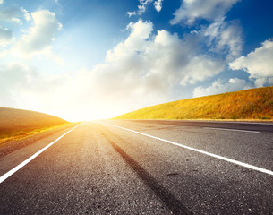 Empty motion blurred asphalt road and blue sky with blurred clouds