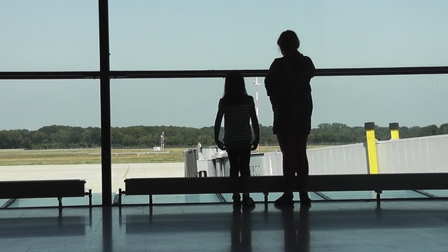 Little girls in the airport near the window
